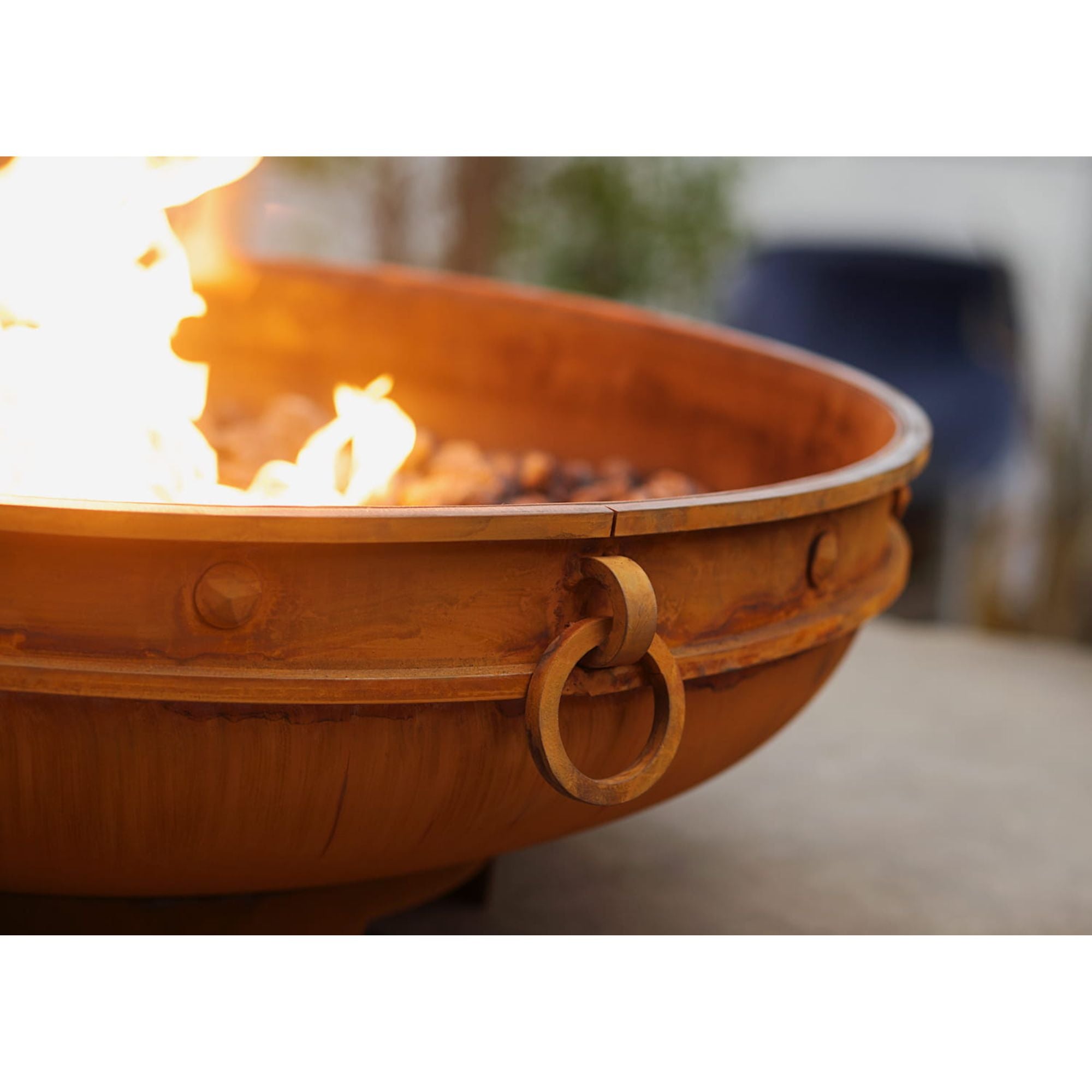 Copper fire pit with flames on a blurred background