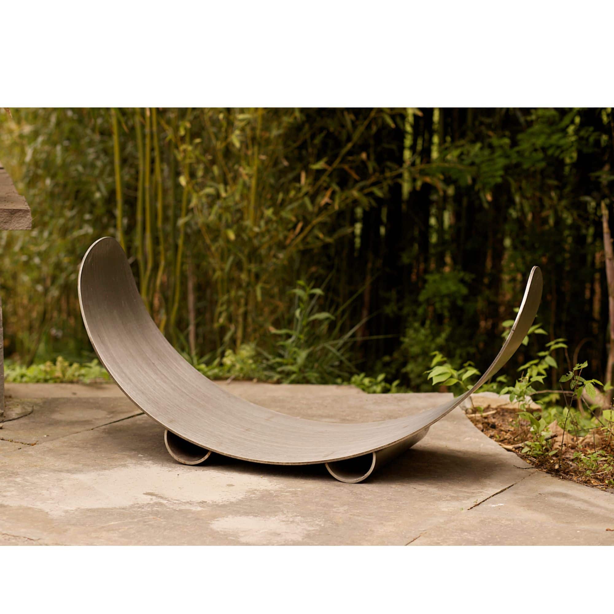 Carbon steel wood log rack in a natural setting with bamboo