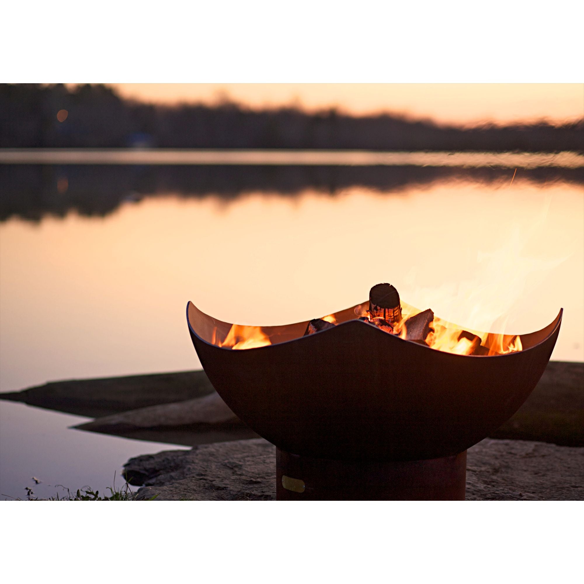 Fire pit shaped like a Manta Ray by a lake at sunset
