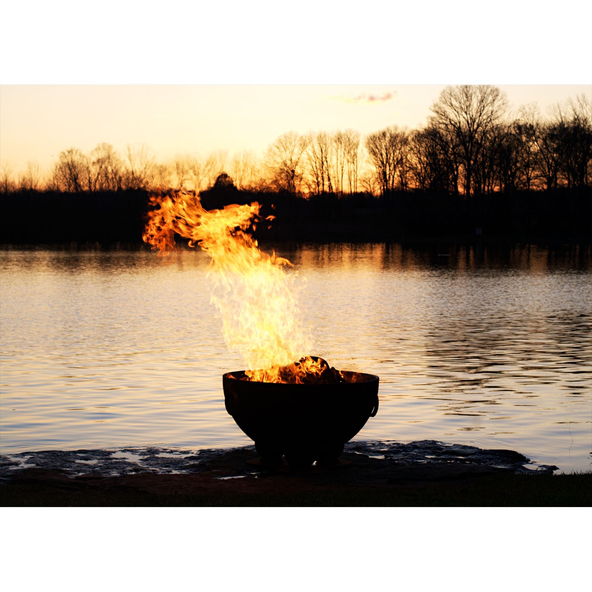 Fire pit on a lake with a sunset background