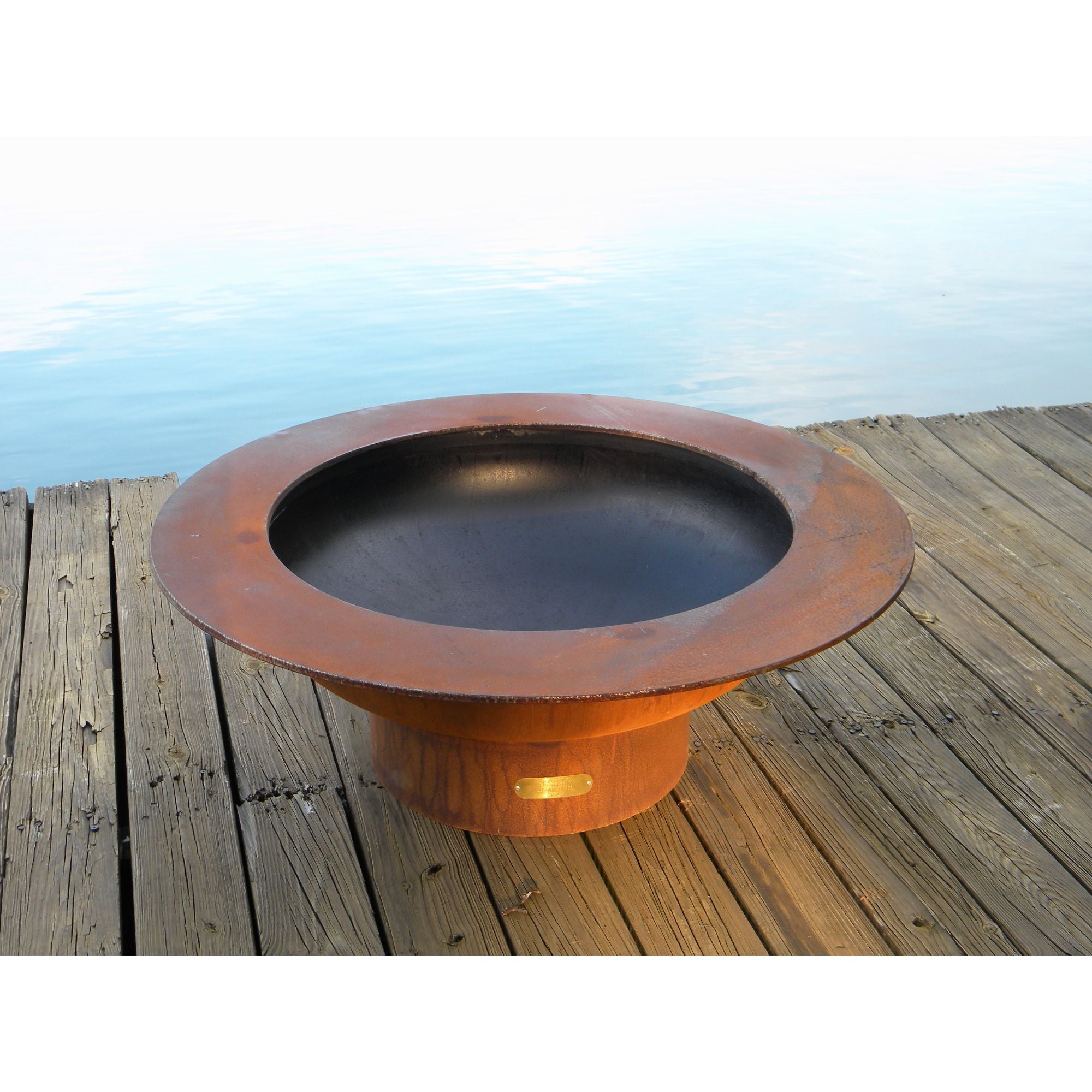 Copper fire pit on a wooden deck with a scenic background