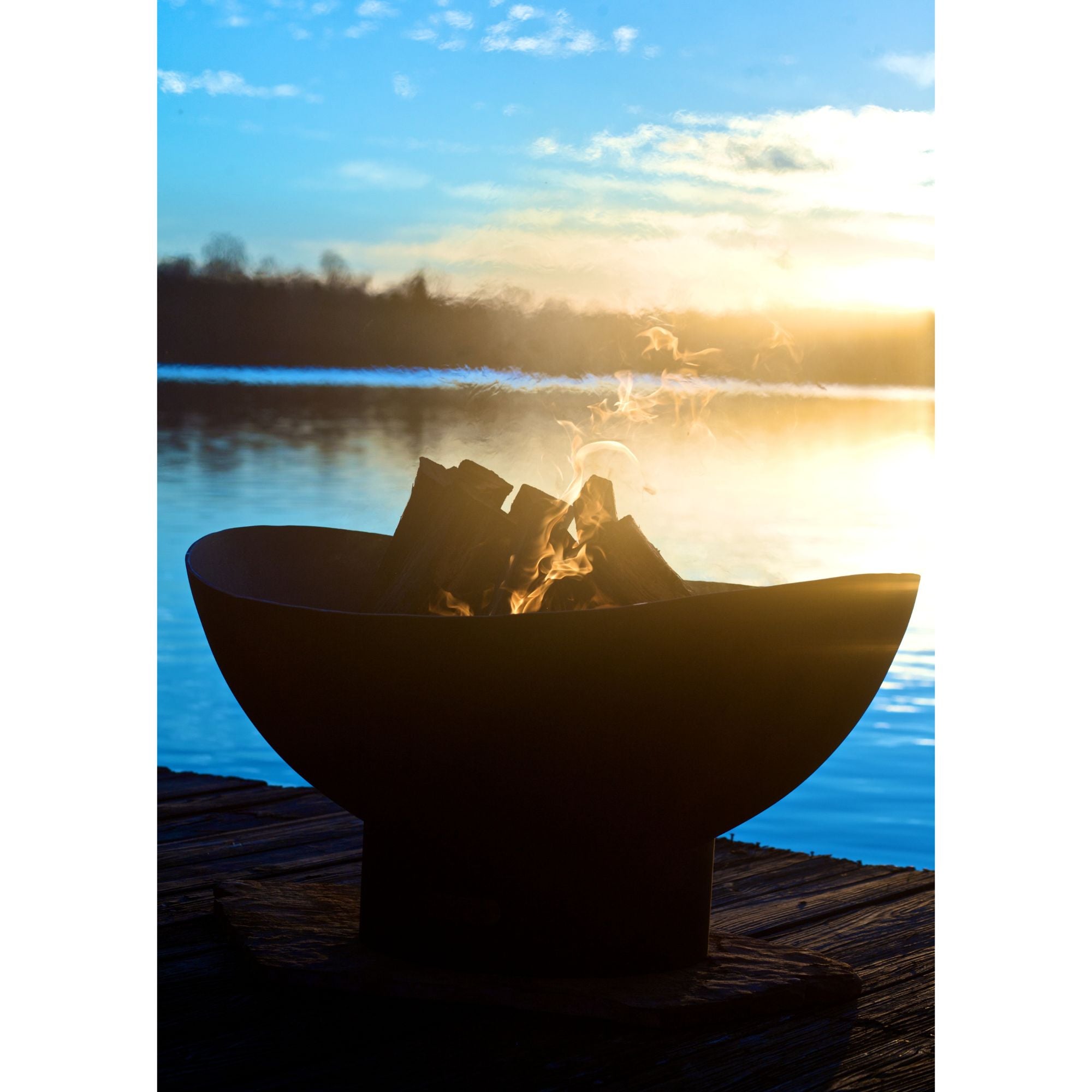 Fire pit on a dock by a lake with sunset in the background