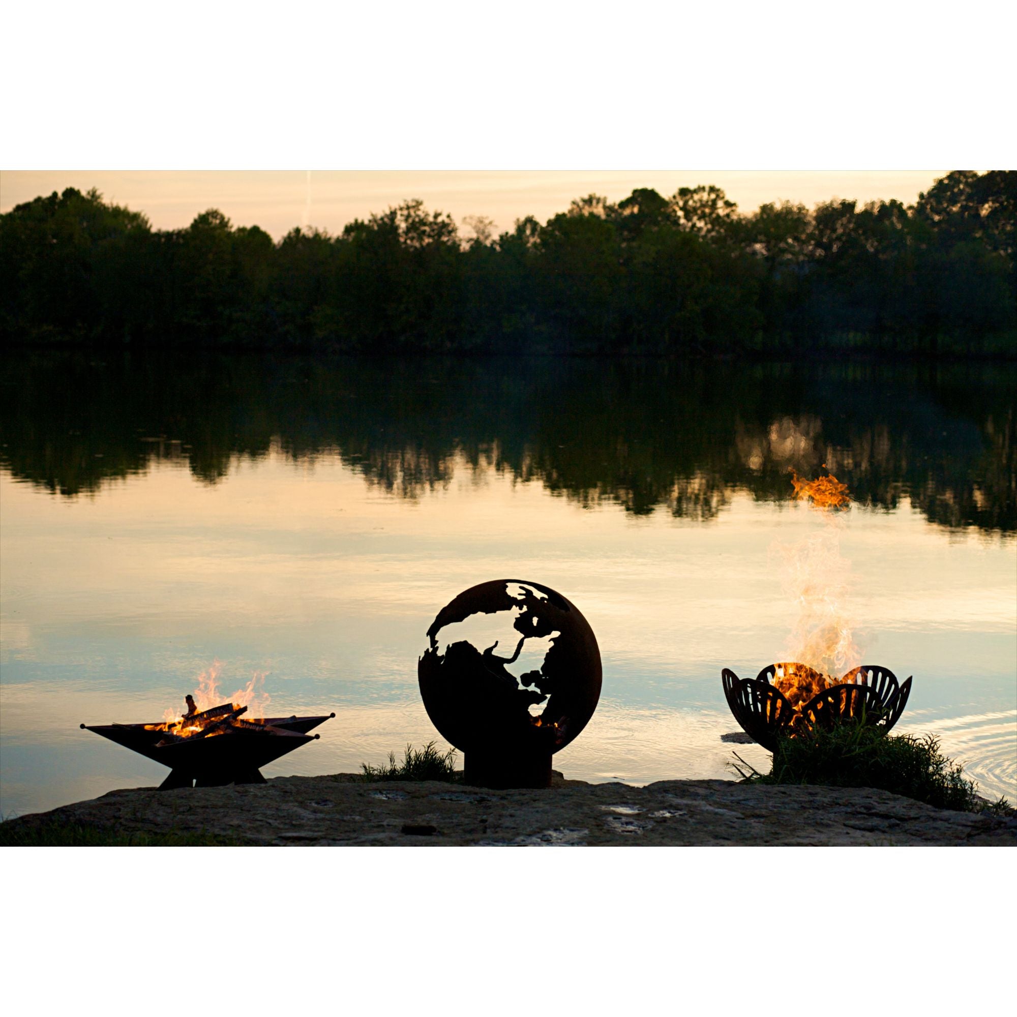 Fire pit with decorative design by a lake at sunset