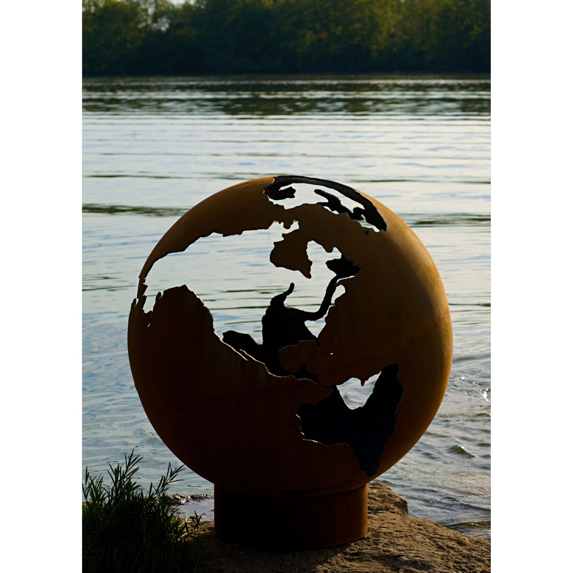 Fire pit on a dock by a lake with sunset in the background