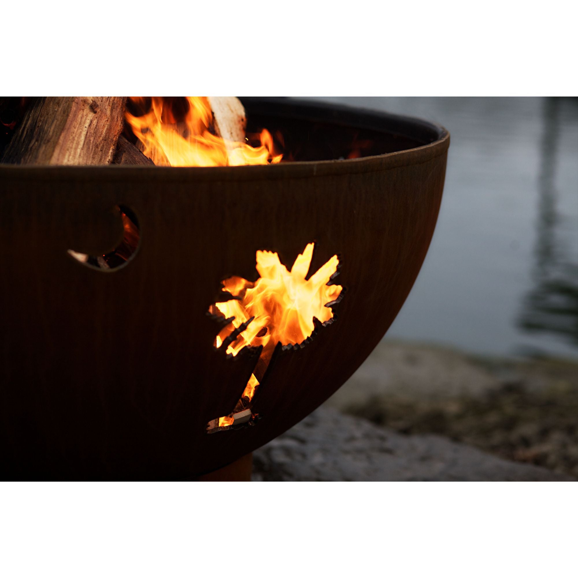 Fire pit with flames burning inside, set against a natural background.
