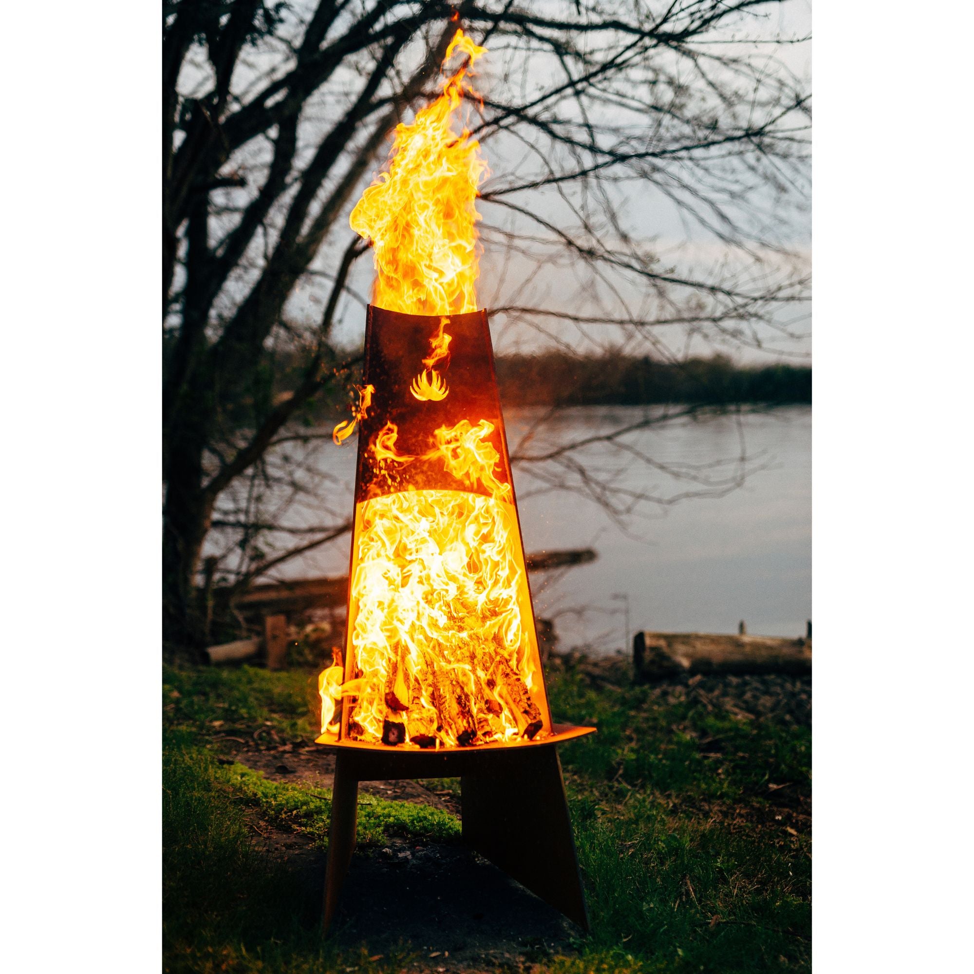 Fire pit with flames burning near a body of water