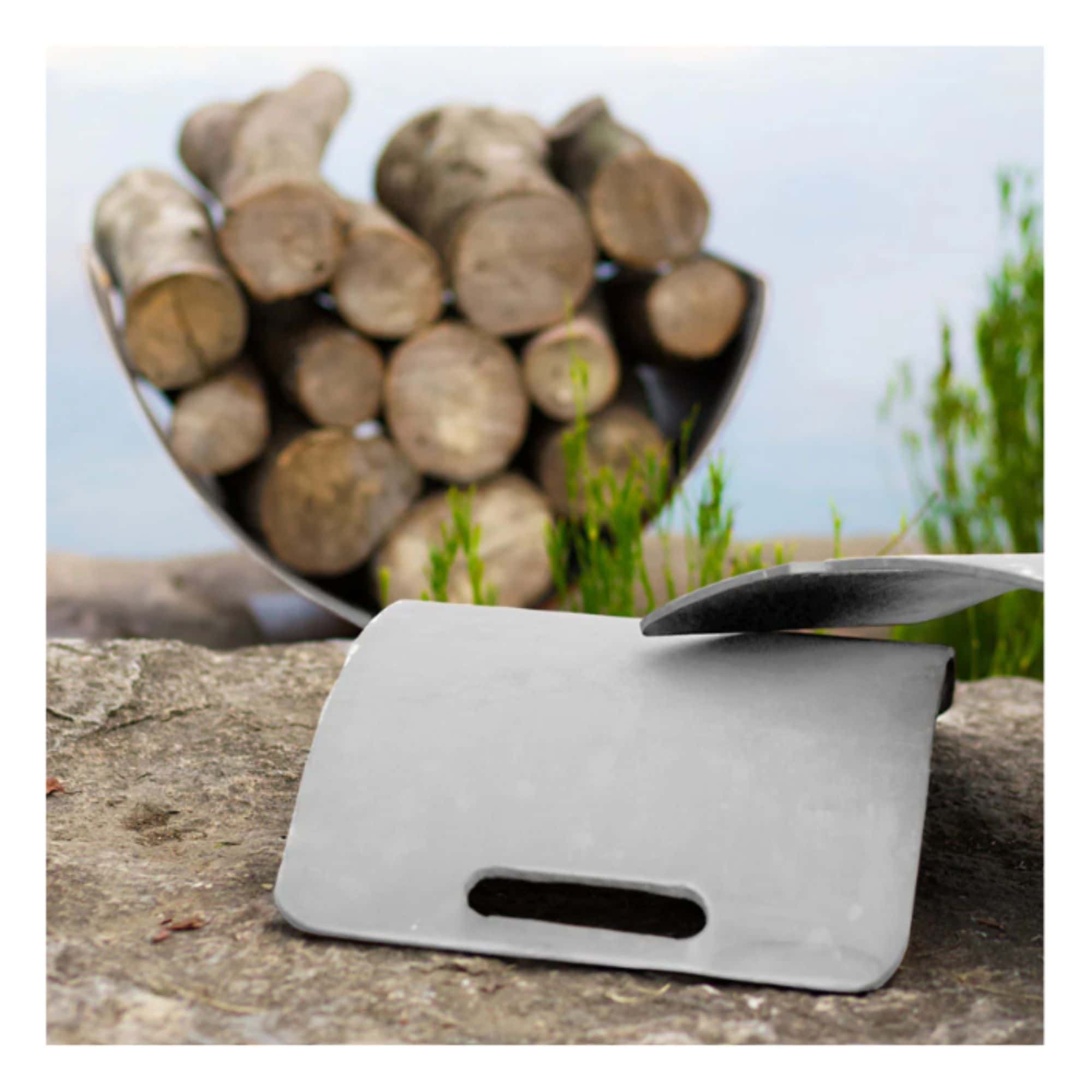 stainless steel log rack on a stone surface with stacked logs in the background