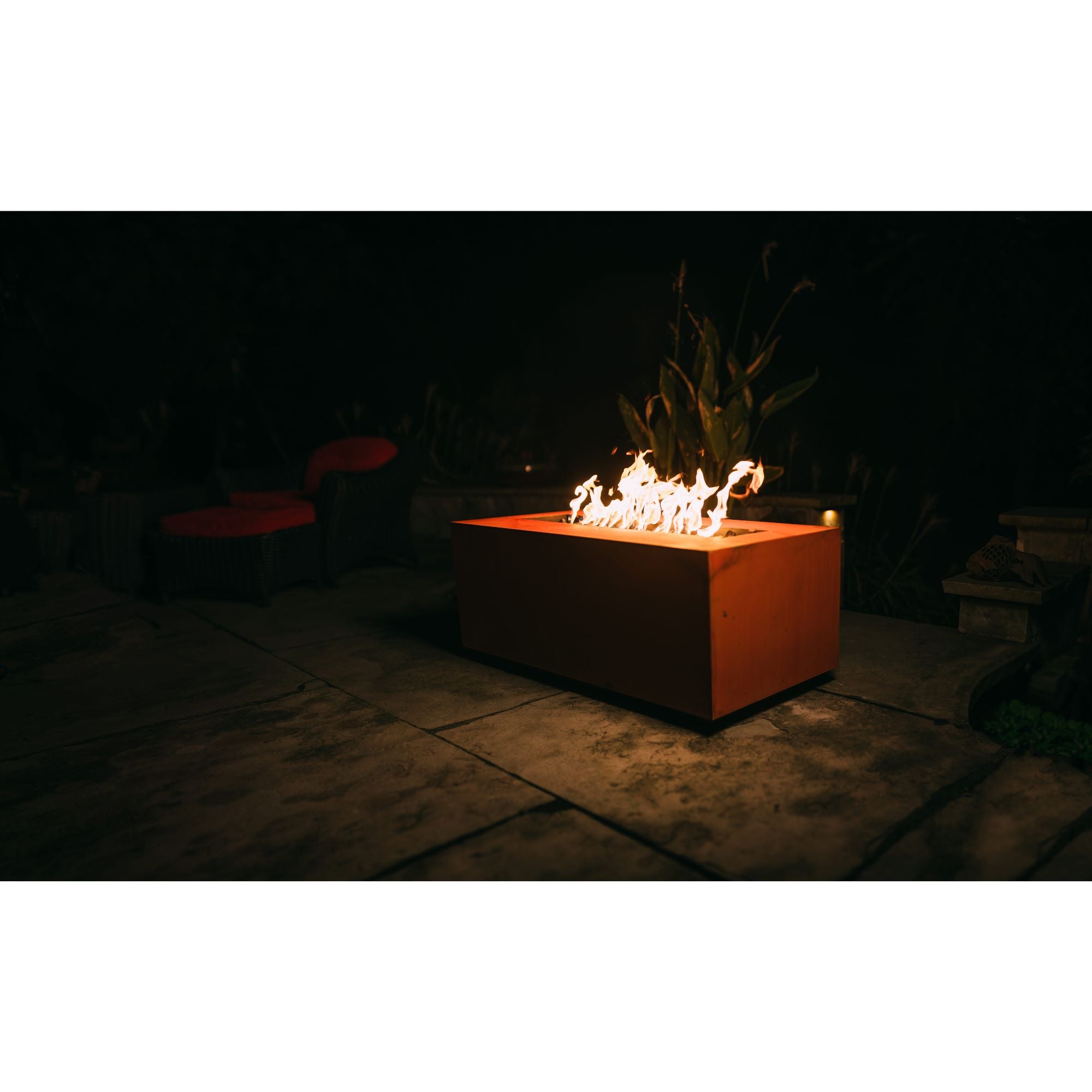 Fire pit with flames glowing in the dark outdoors