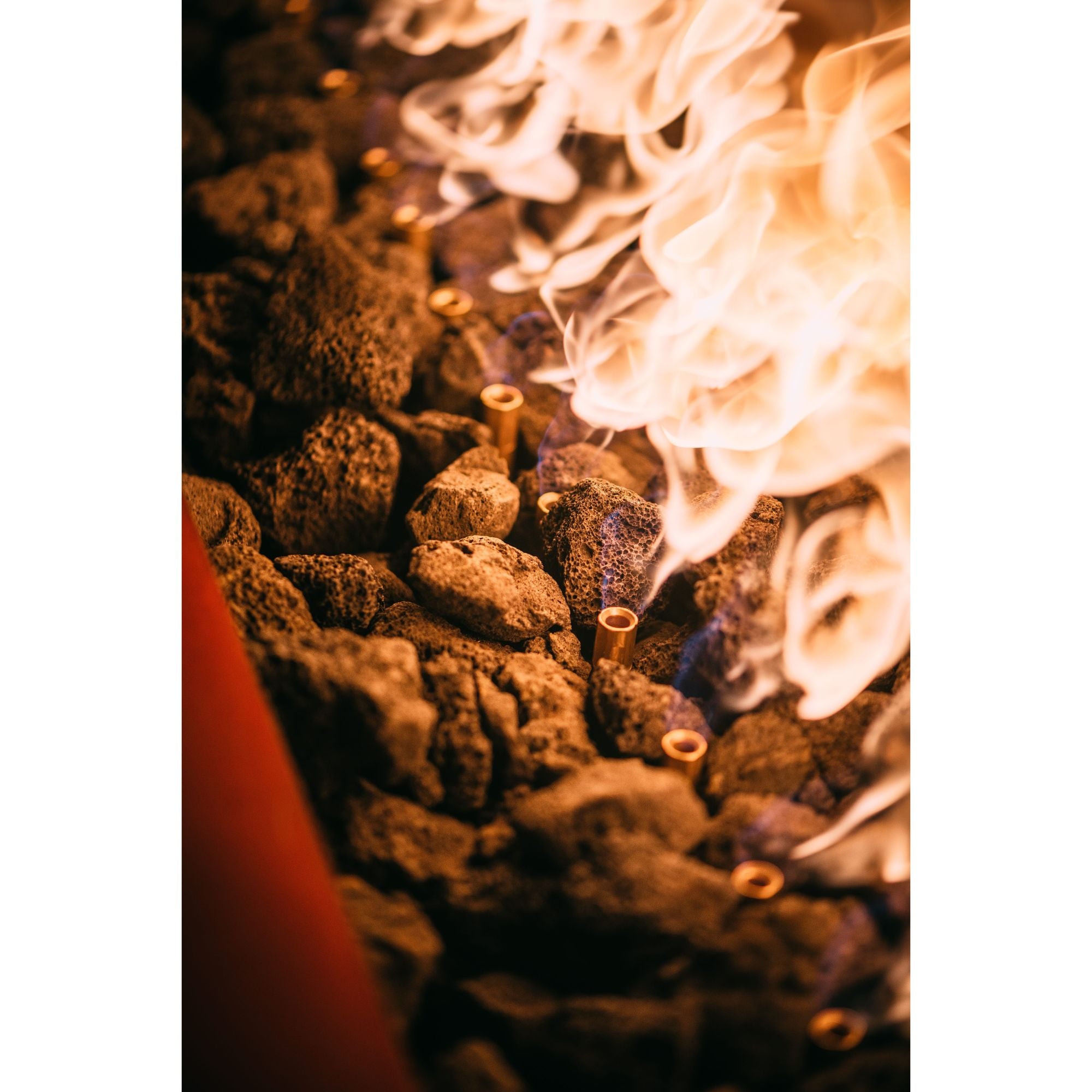 Close-up of burning incense sticks with smoke rising from brown resinous material.