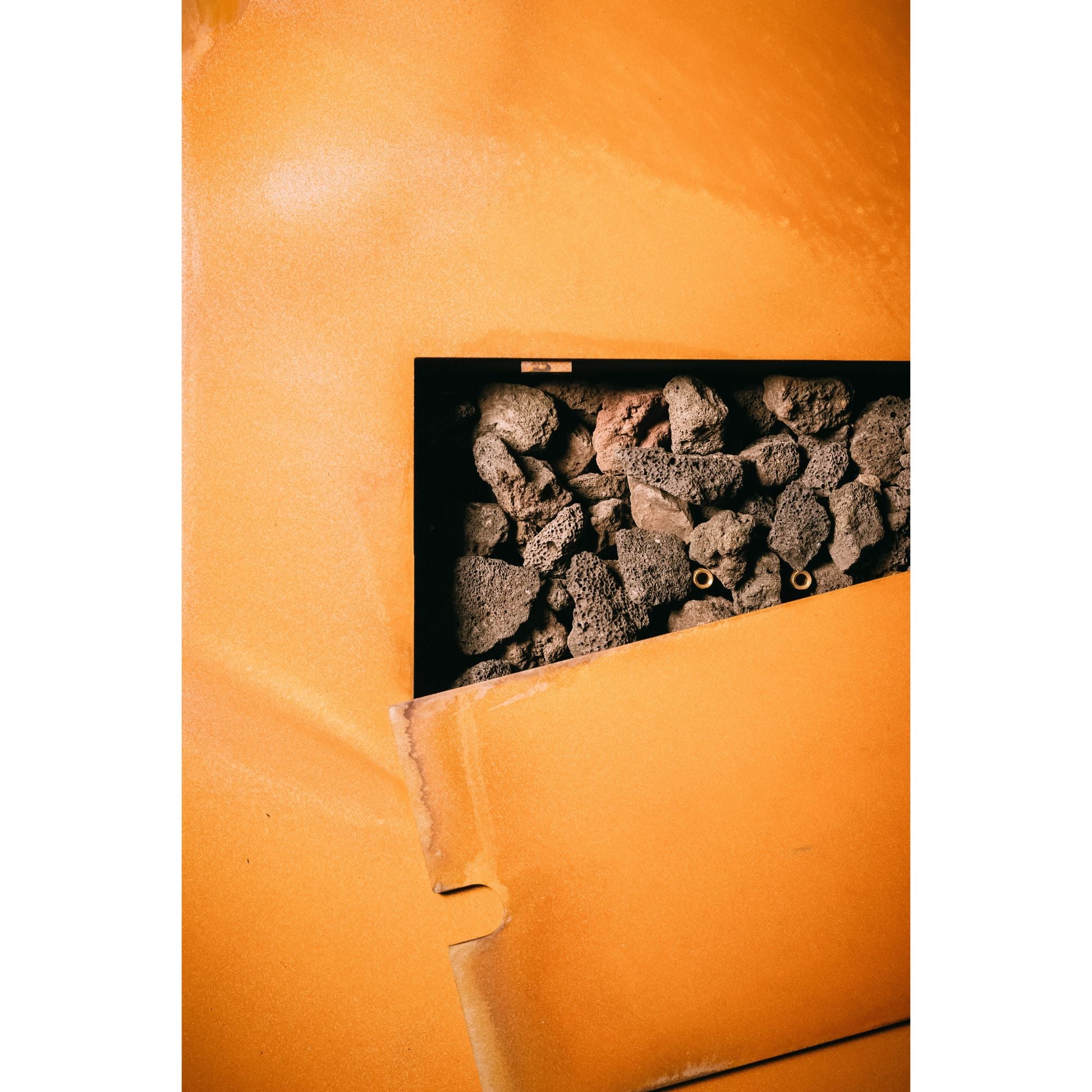 Close-up of a textured orange surface with a black rectangular inset showing rocks.