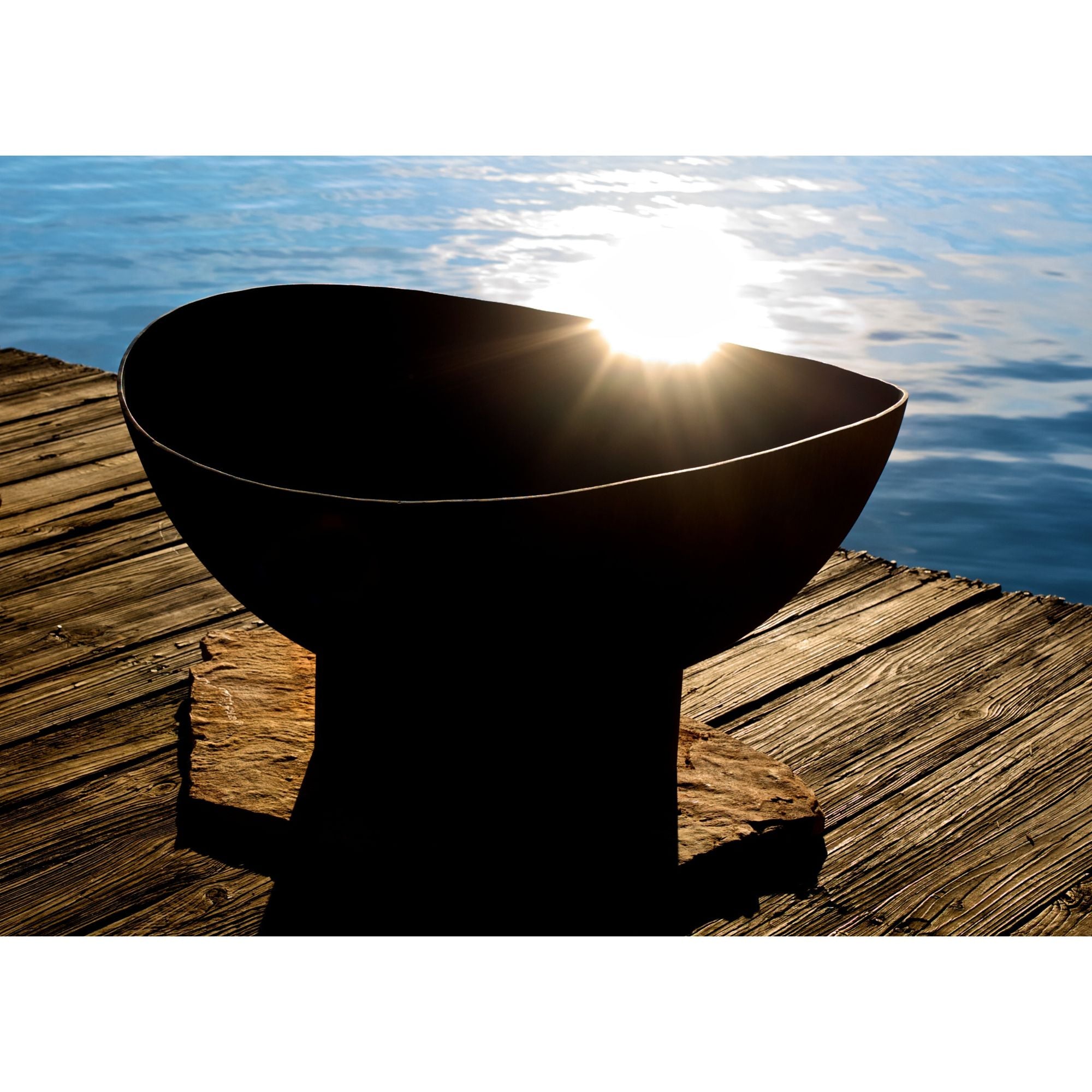 Black bowl on a wooden dock with sun reflecting off water