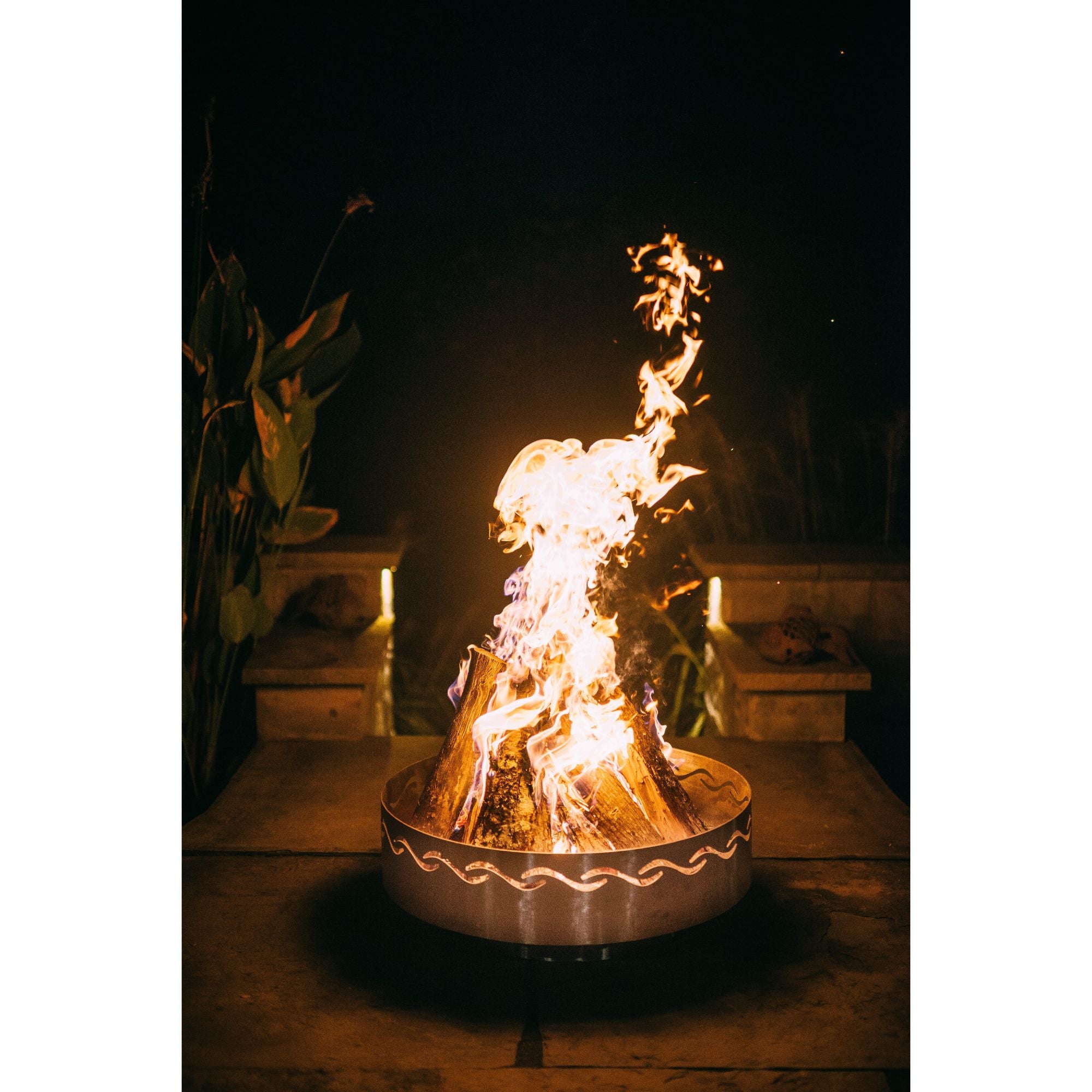 Fire pit with flames at night in an outdoor setting
