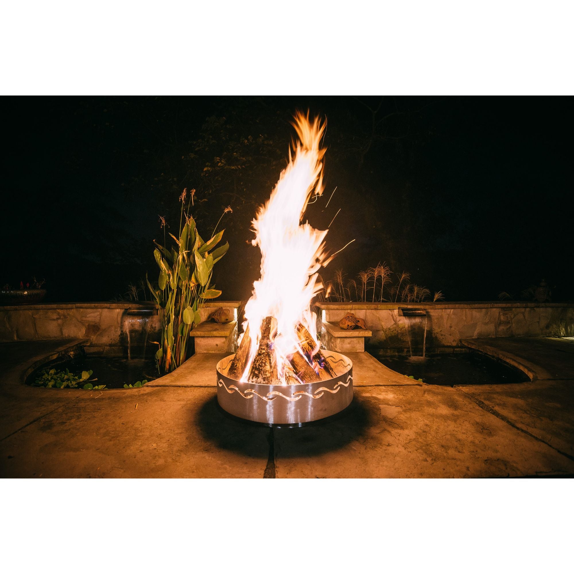 Fire pit with flames at night in an outdoor setting