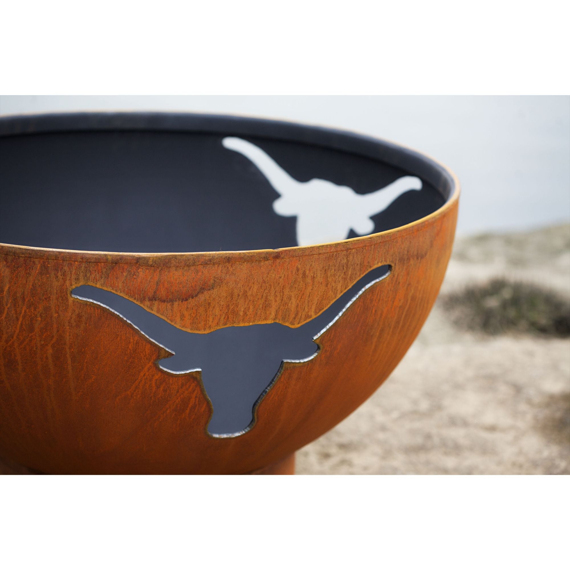 Fire pit with longhorn design on a blurred natural background