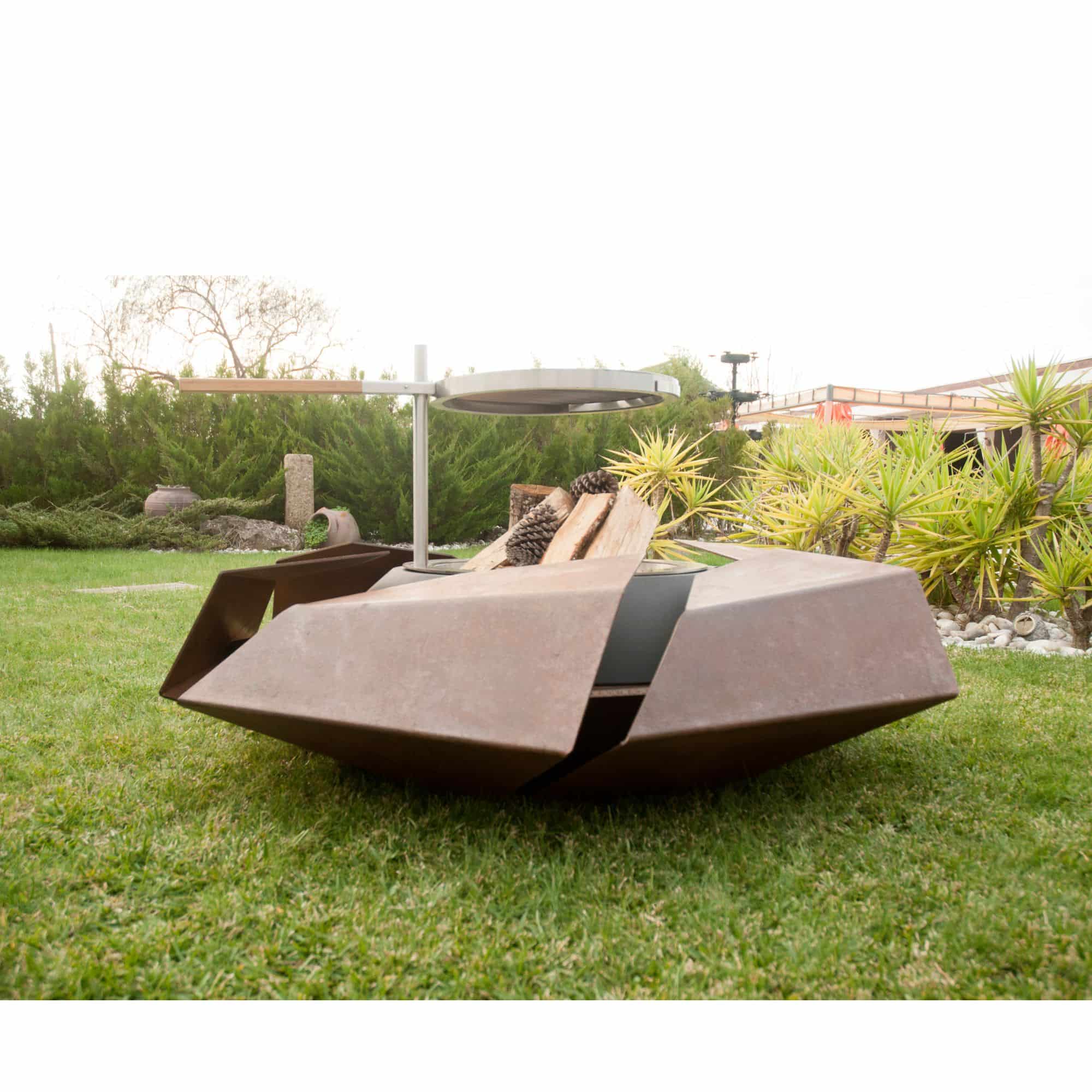 firepit with wood logs standing on grass