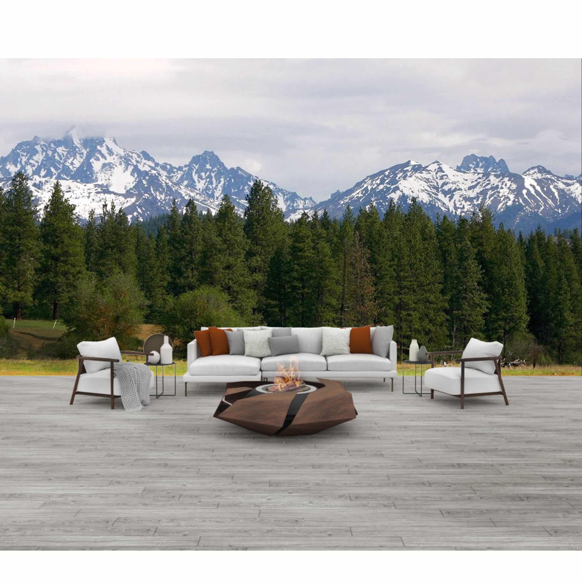 firepit with flames burning, standing on a wooden surface with trees and mountains in the background