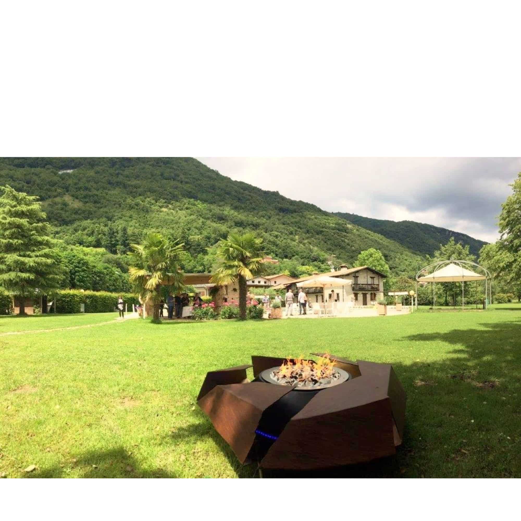 firepit with burning flames standing on grass