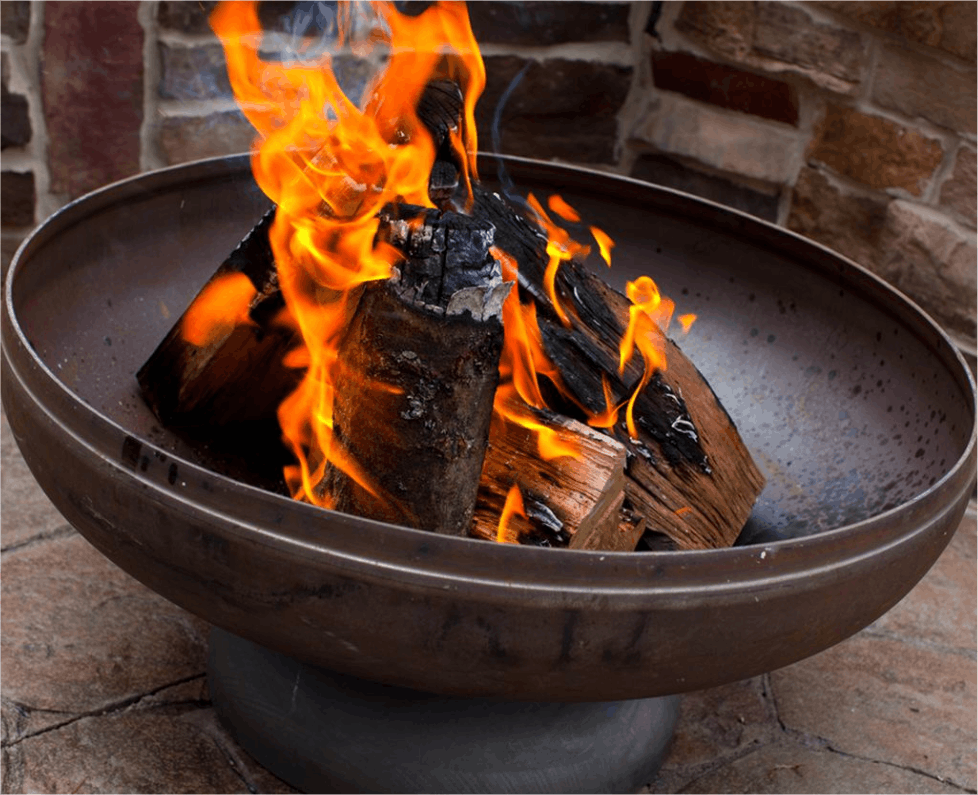 Fire pit with flames and glowing embers on a stone patio