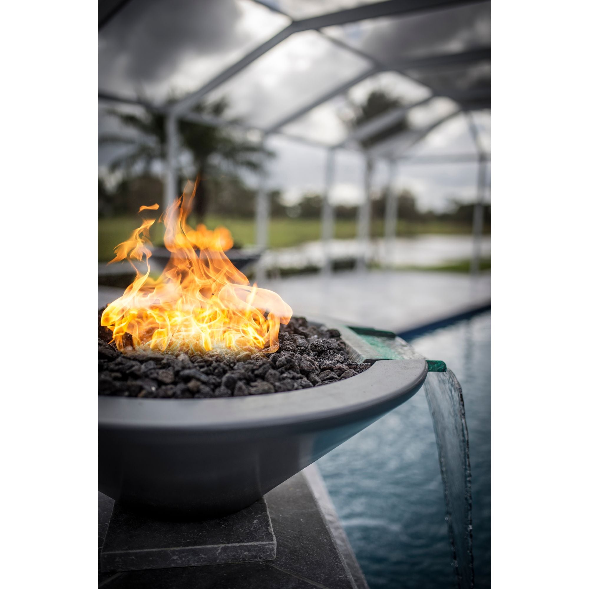 fire and water bowl with flames with a water scupper by a indoor pool
