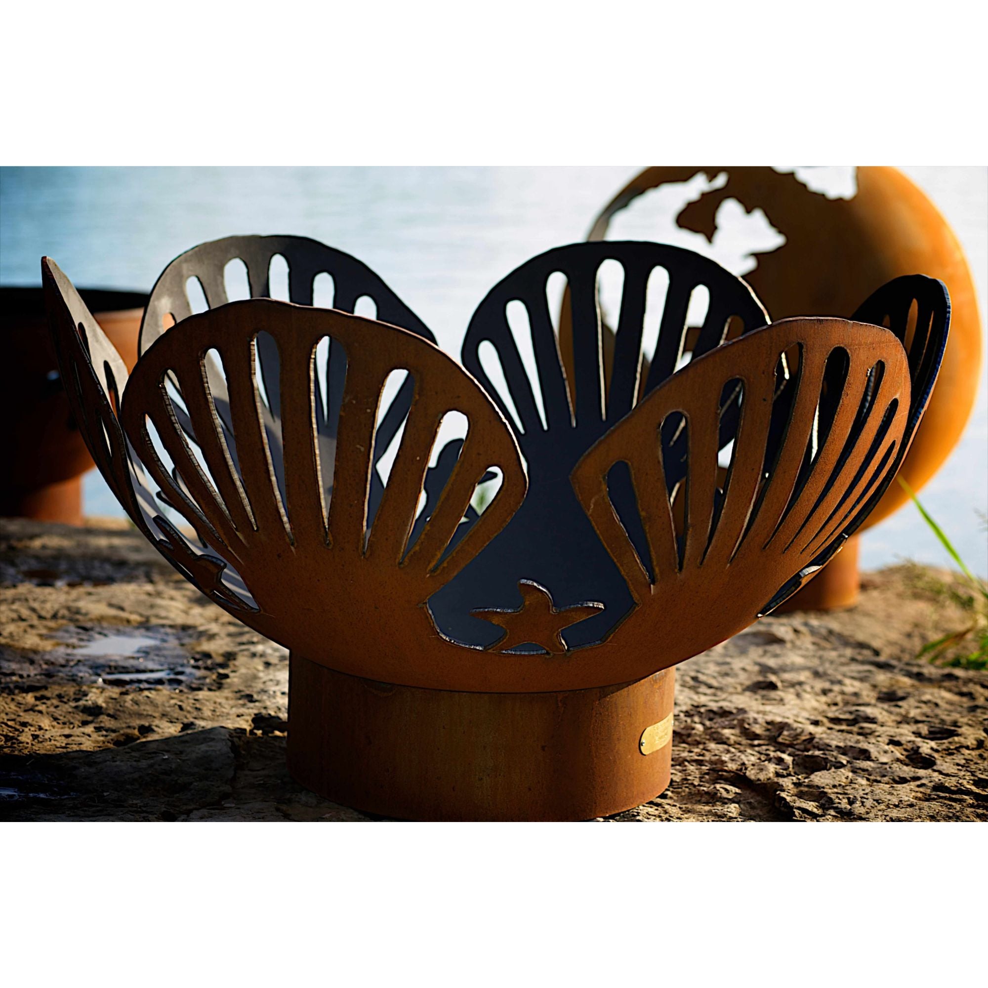 Metal fire pit with shell design on a natural background