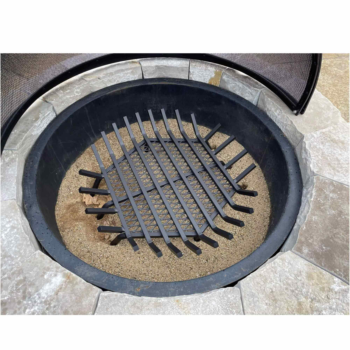 Master Flame round fire pit grate installed in a stone wood-burning fire pit