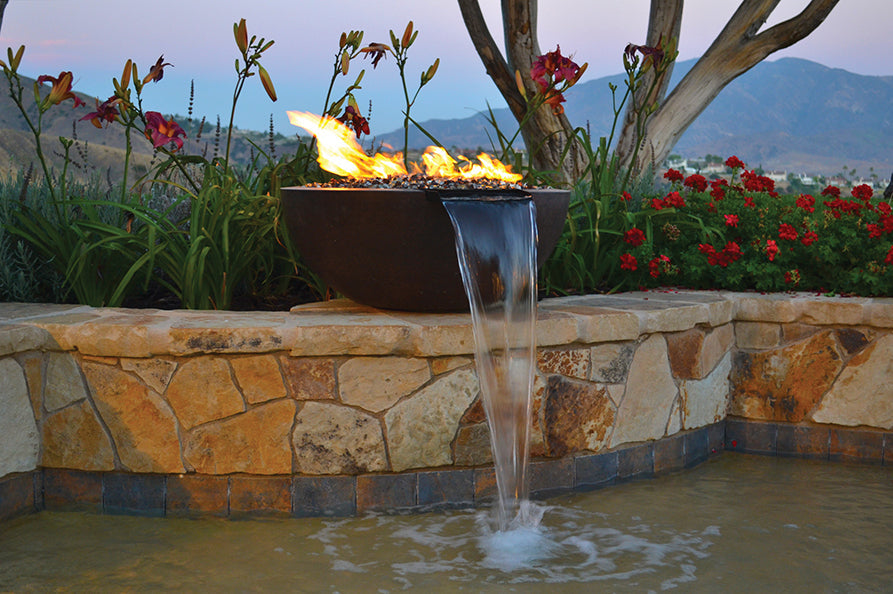 Fire and water bowl on a stone wall with the flame lit