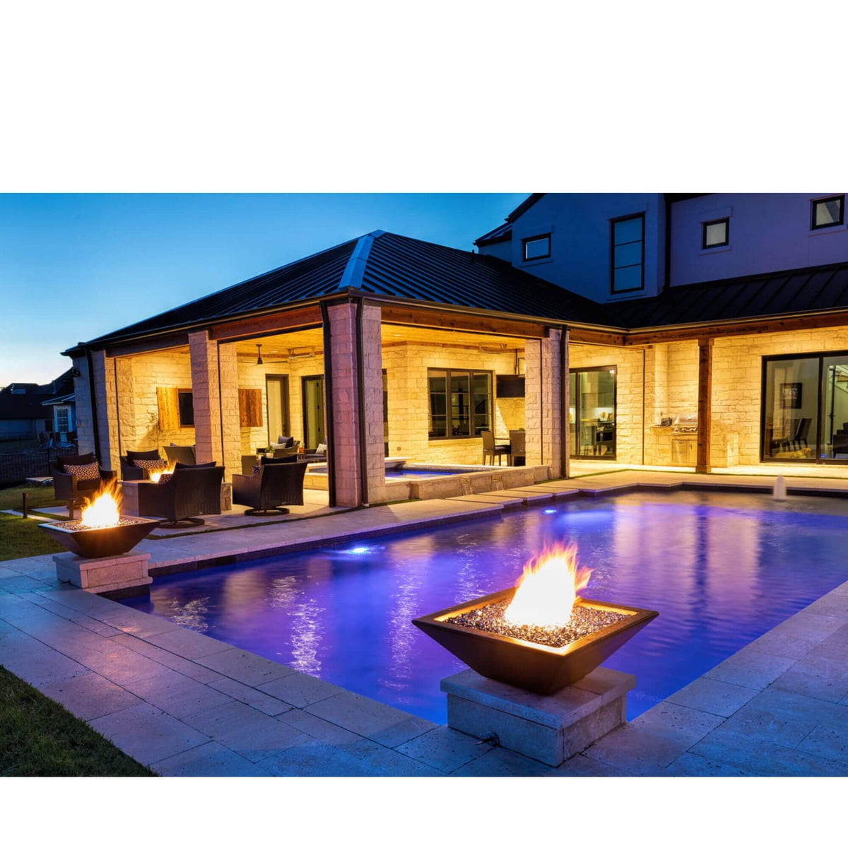 Concrete gas fire bowl by a pool at dusk
