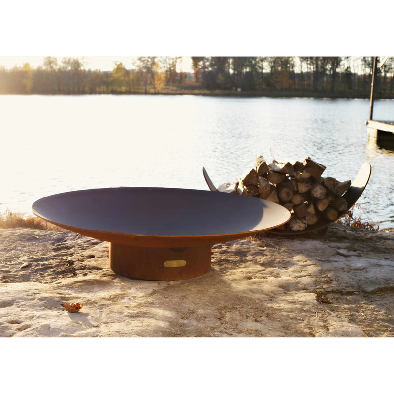 Fire pit and stacked logs on a lakeside patio