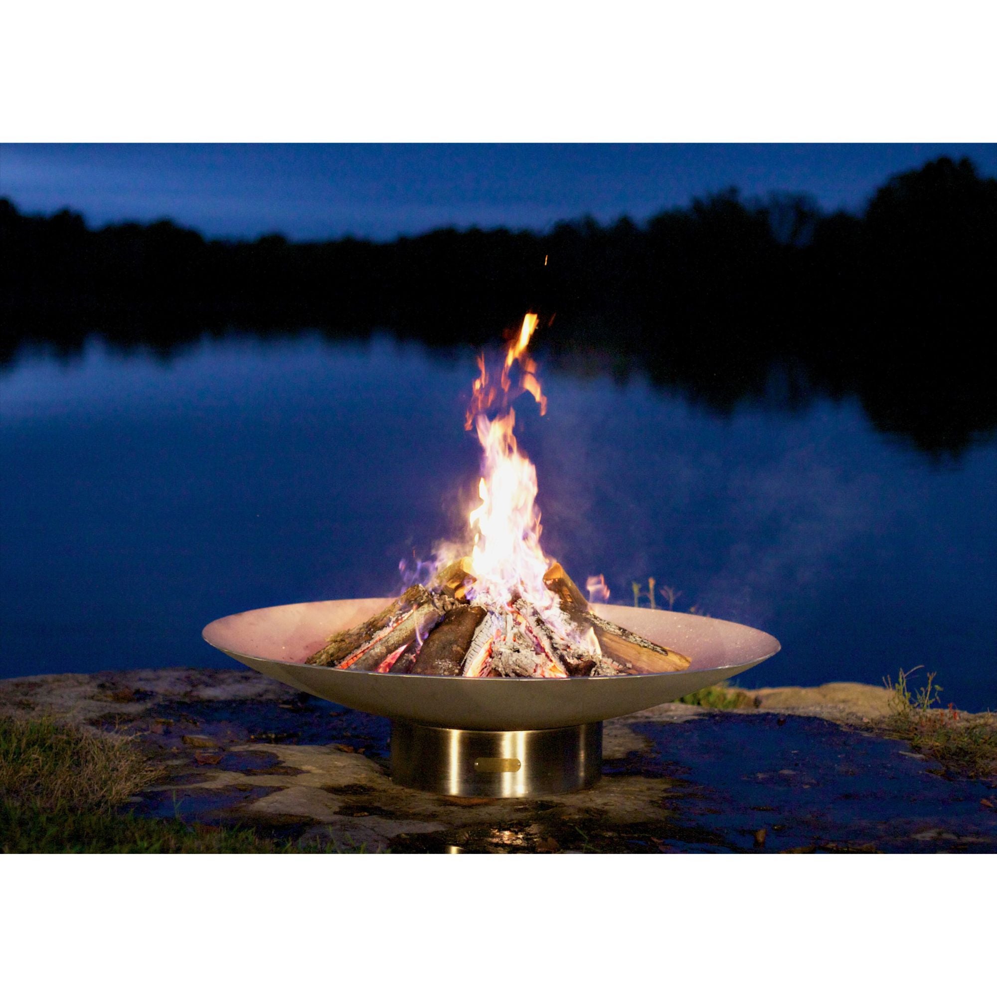 Fire pit with flames burning brightly against a dark water background