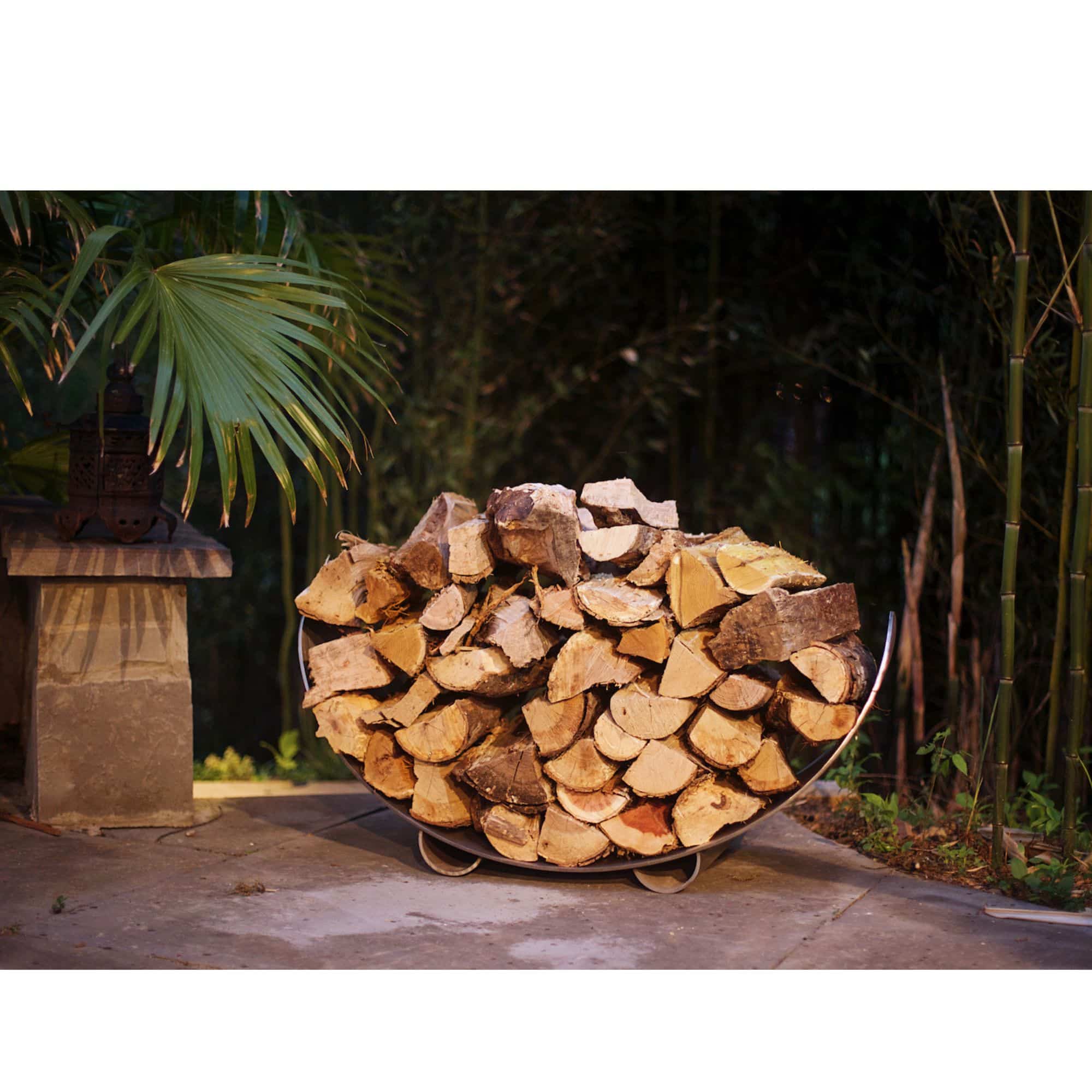 Stack of firewood in a metal holder with a natural outdoor background