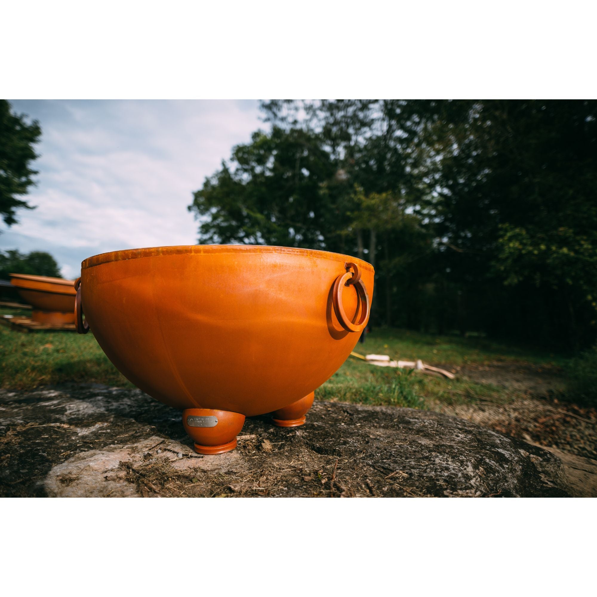 Orange bowl with a logo on a rock outdoors