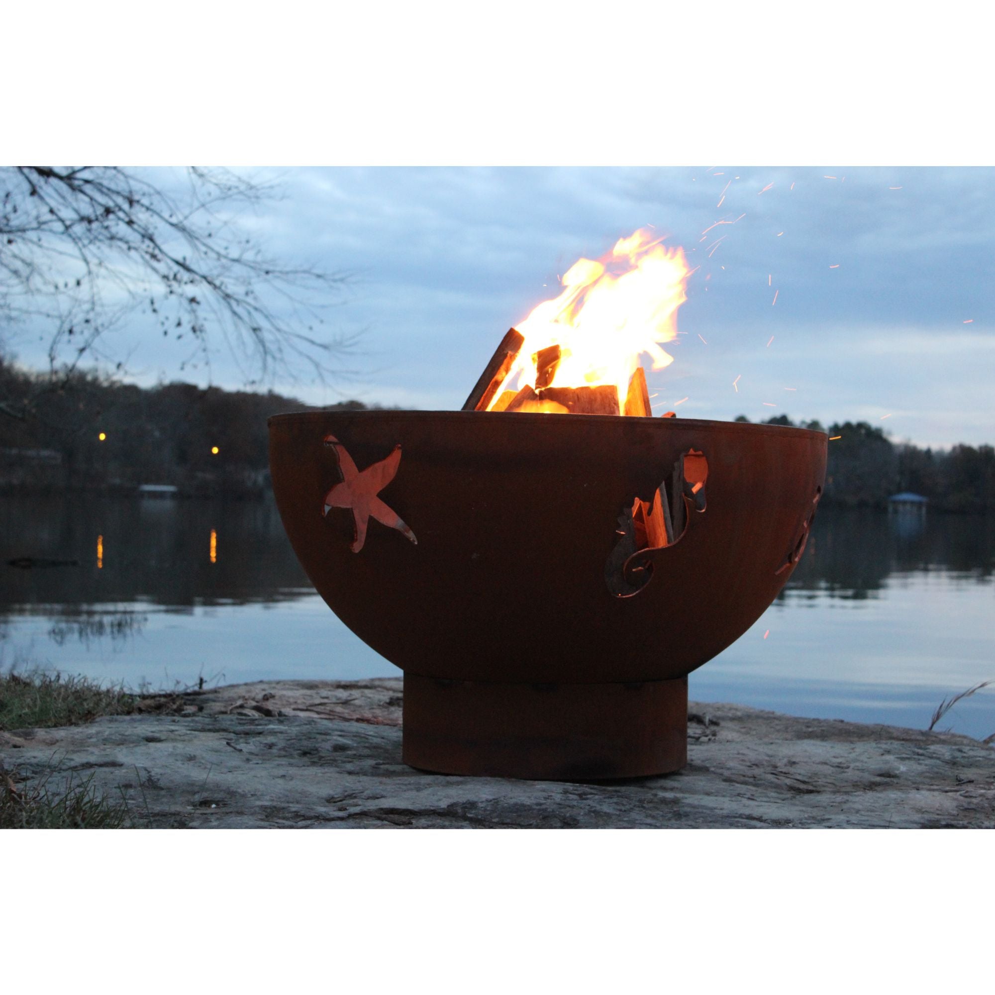 Fire pit with starfish design by a lake at dusk