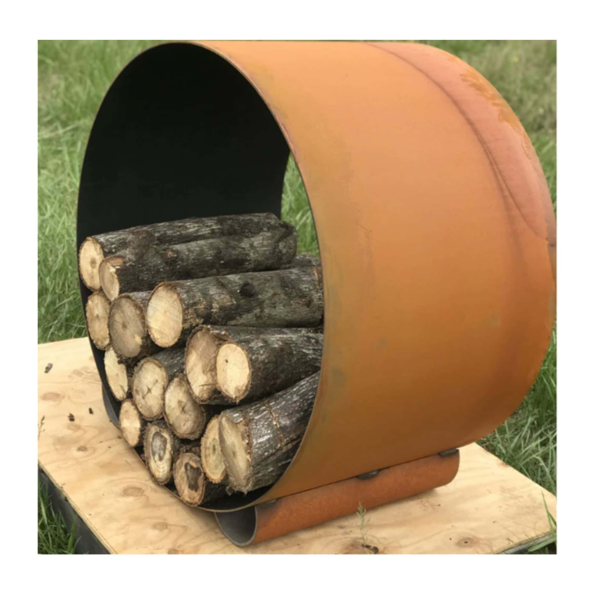 Orange metal log holder with logs on a grassy background