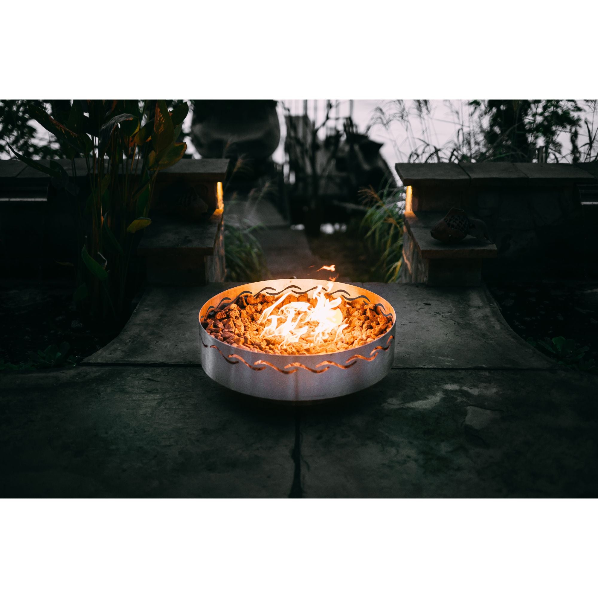 Fire pit with flames glowing in a dark outdoor setting