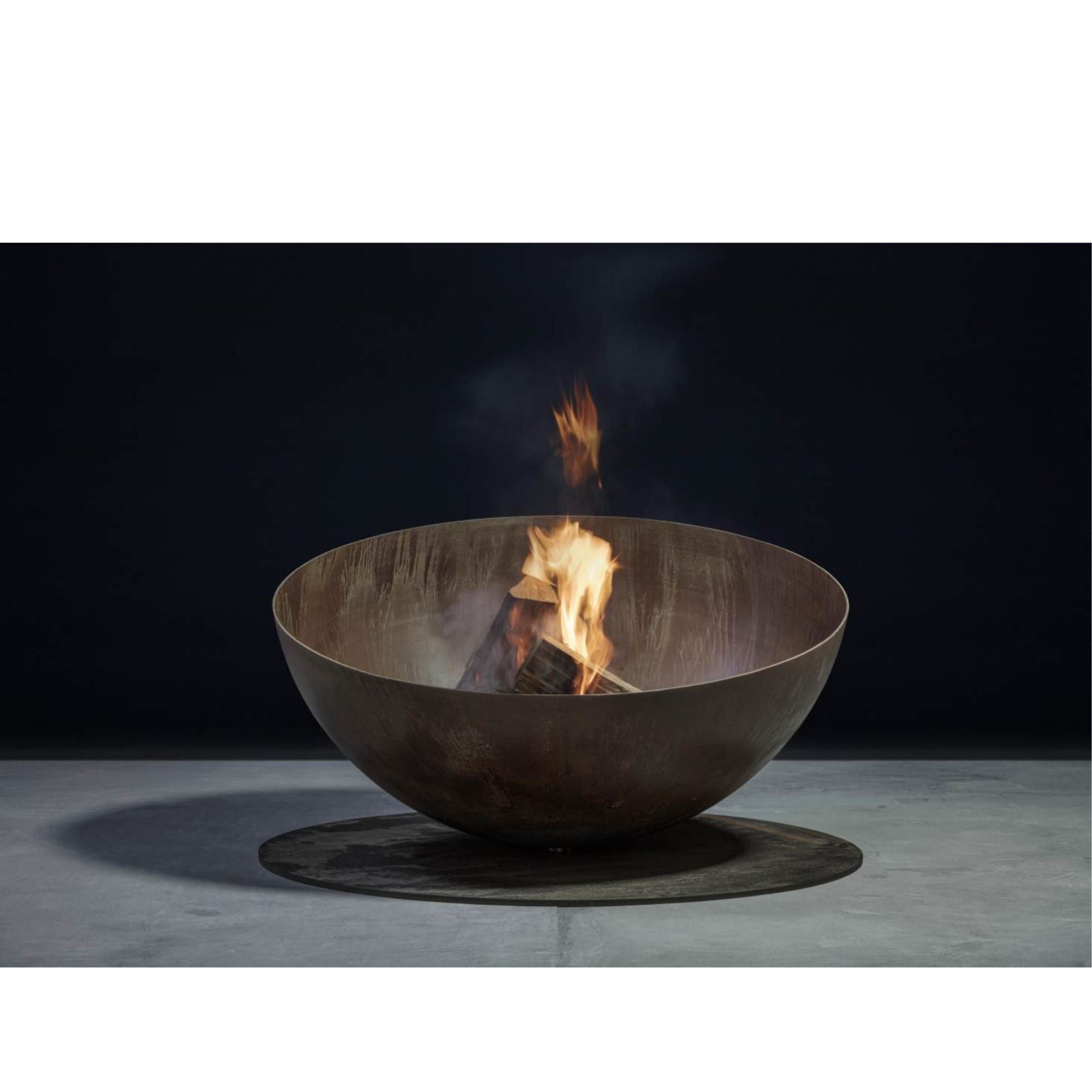 Steel fire pit with flames on a dark background