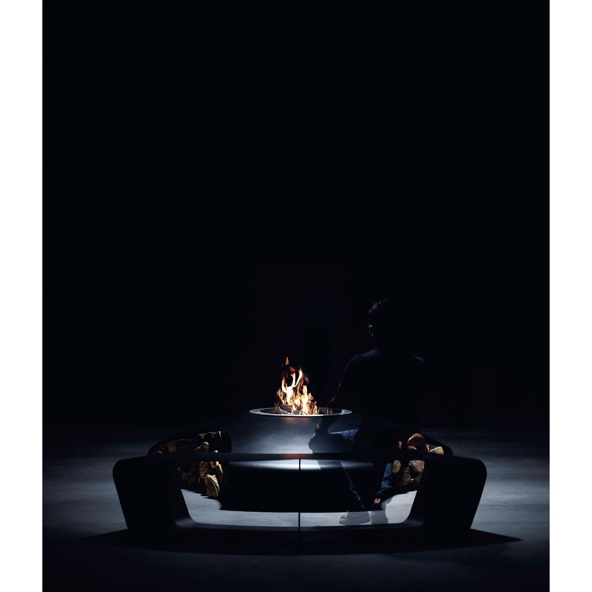 Modern fire pit with flames in a dark setting