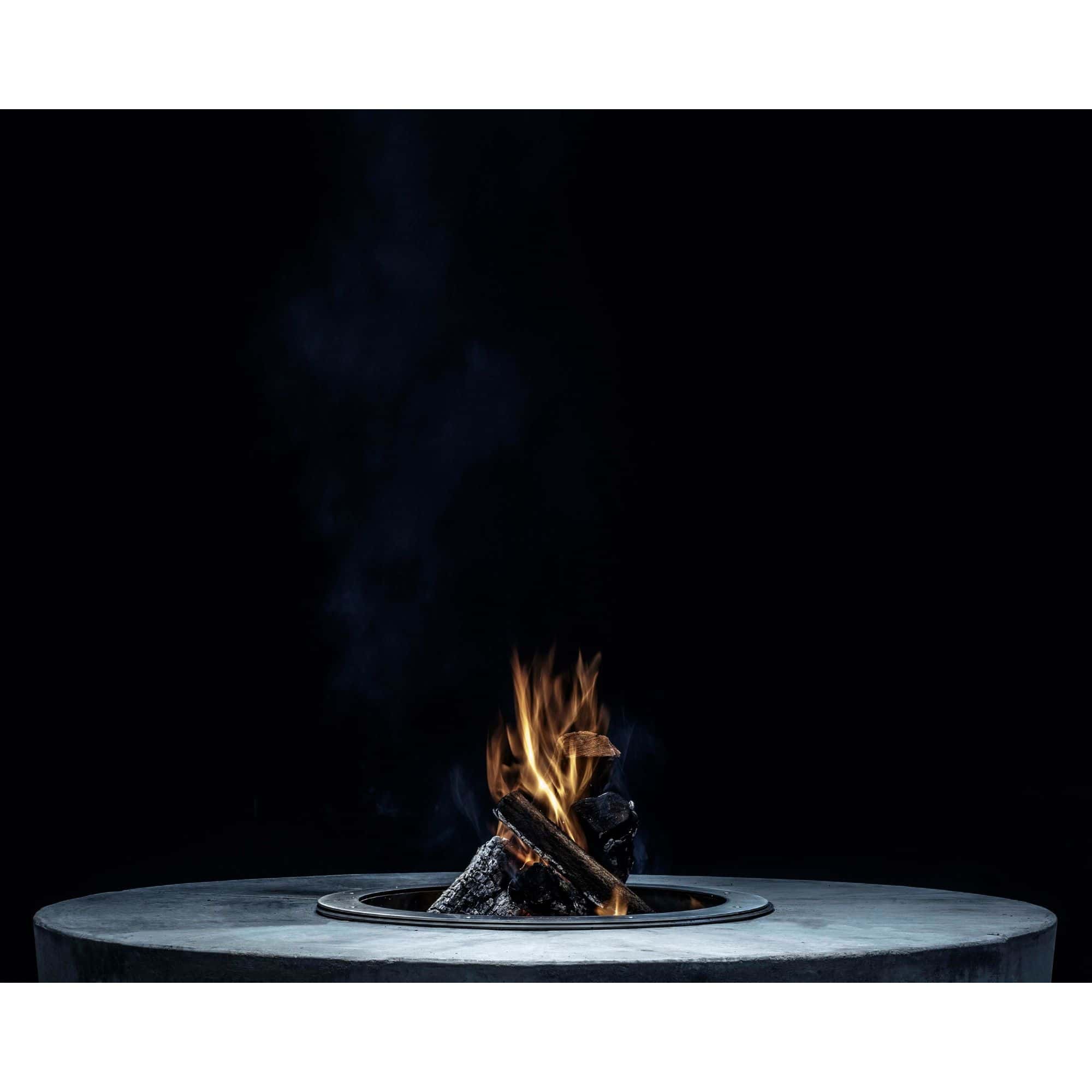 Fire pit with flames and smoke on a dark background