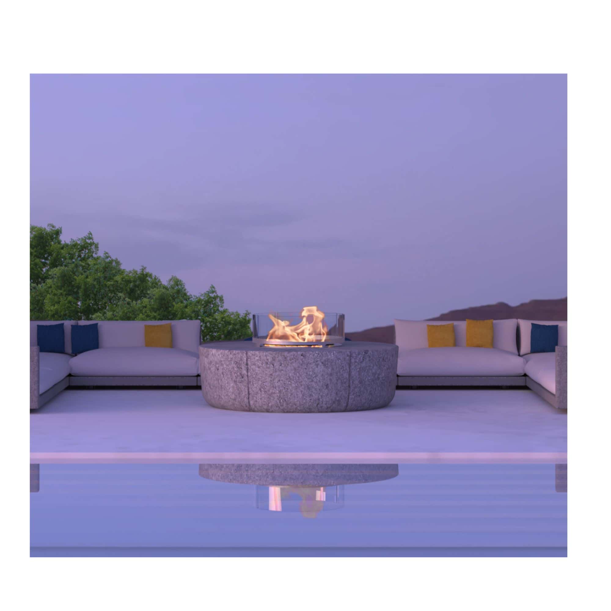 Outdoor patio with fire pit, seating area, and pool at dusk.