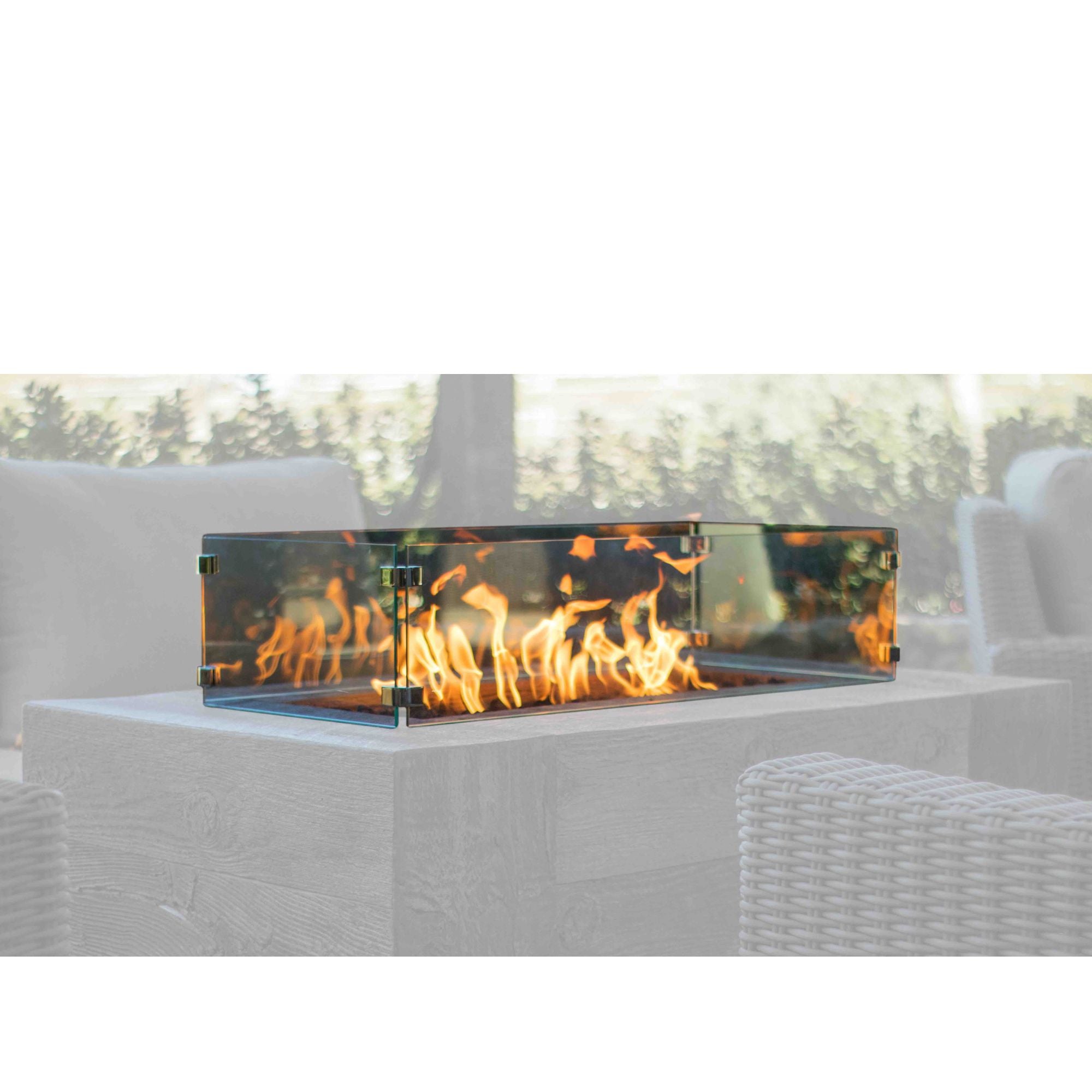 Outdoor fire pit with flames in a patio setting with a glass wind guard