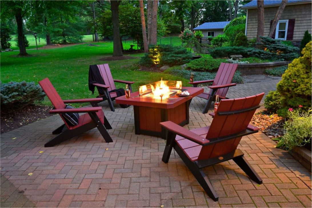 fire pit with flames and chairs in a backyard setting