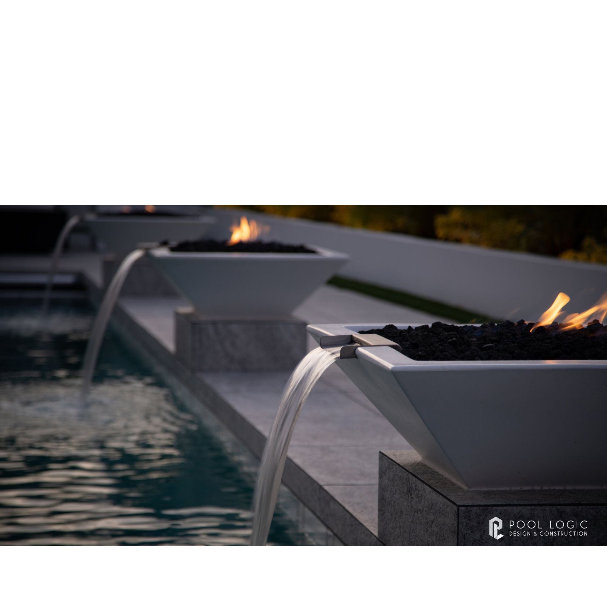 Modern fire pit and water feature by a pool 