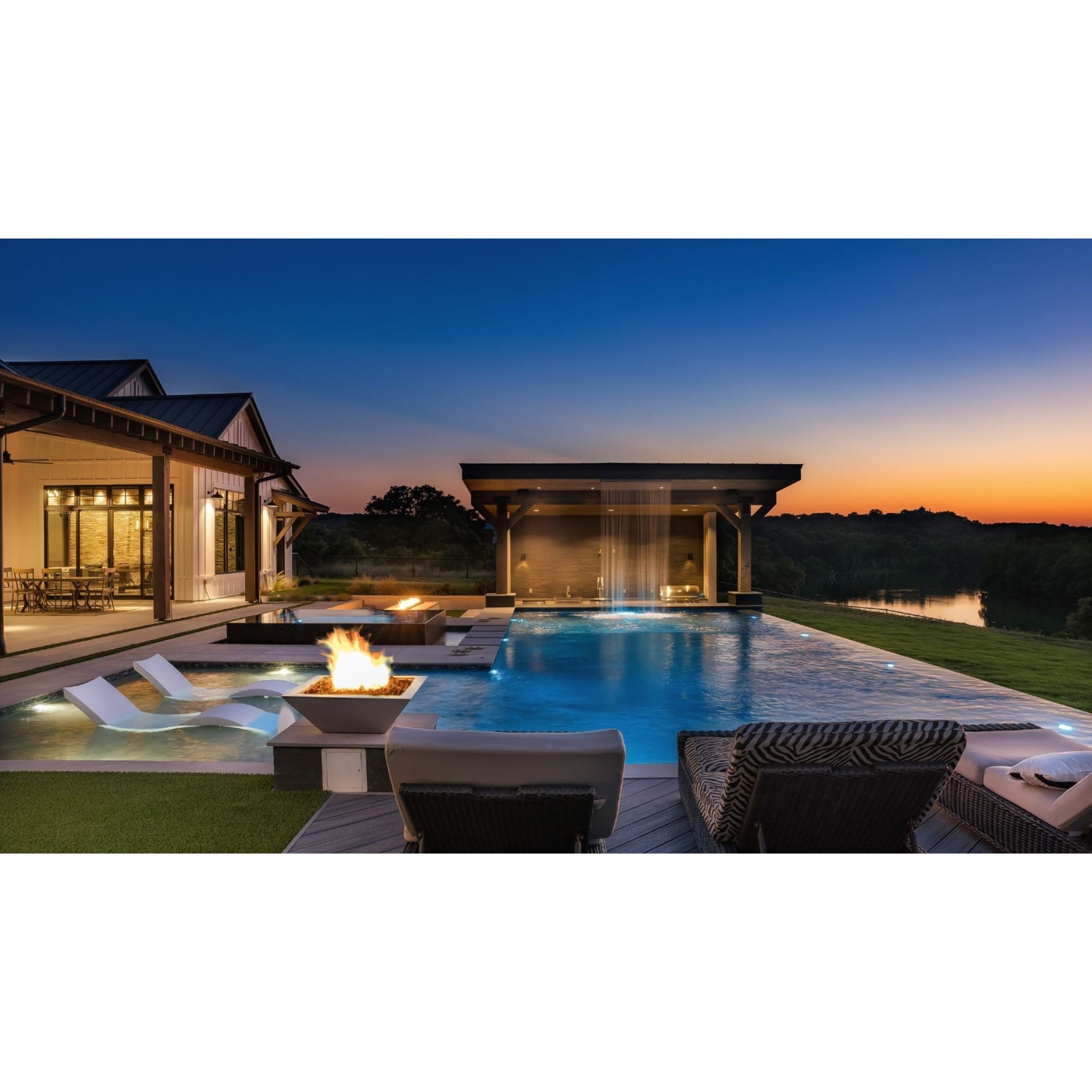 fire bowl with flames by a pool at night time